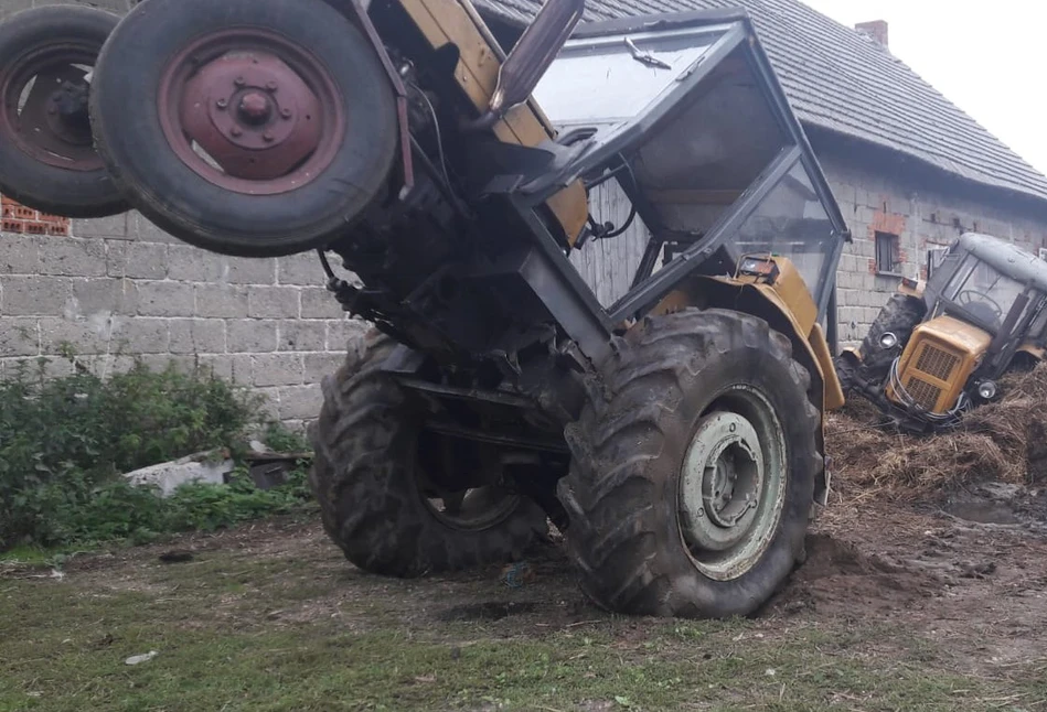 Utopił ciągnik w oborniku i utknął w kabinie. Policjanci uratowali go na barkach