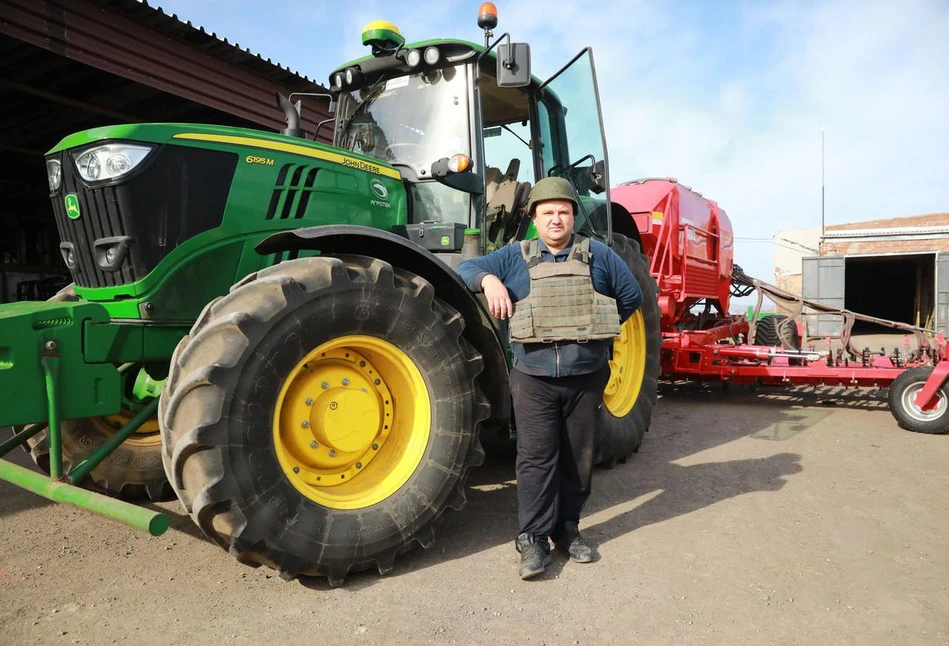 Kamizelka kuloodporna, hełm i traktor z maszyną - takim zestawem pracują w polu ukraińscy rolnicy pod rosyjskim ostrzałem